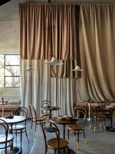 Warm and inviting restaurant interior with wooden tables and chairs, multiple dining tables and chairs, and a focus on comfort