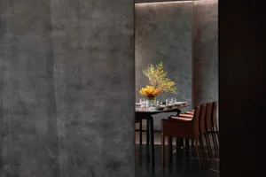Sophisticated dining area with a large wooden table, multiple chairs, wine glasses, and a warm ambiance