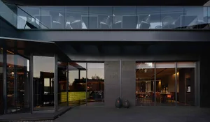 A modern restaurant with glass walls, multiple chairs, and various tables in a spacious and inviting atmosphere