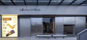 一間店面擁有大型展示窗，陳列腳踏車及其他物品，店外有兩張長椅，店內有盆栽