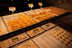 一個充滿各種糕點、蛋糕和餅乾的麵包店展示櫃，以吸引人的方式陳列在玻璃前面