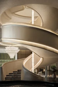 A spiral staircase made of marble in a modern hotel or luxury residence, with a sophisticated and elegant atmosphere
