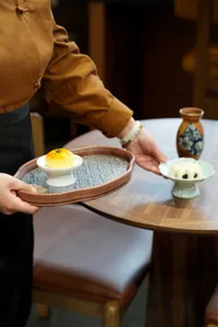餐廳內燈光明亮的餐桌，擺放兩盤食物與兩杯飲料，強調餐桌在場景中的核心地位