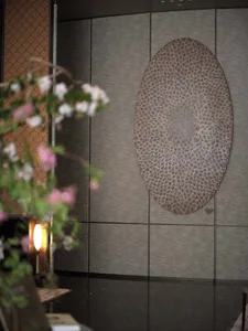 A sophisticated interior space featuring a large leather artwork mounted on a wall, surrounded by smaller decorative circles and elegant atmosphere