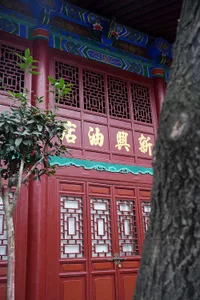 Oriental building with red walls, wooden doors, and intricate designs on its facade, giving it an old and historical appearance