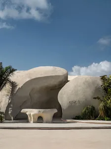 A serene landscape with a large white rock formation and a concrete bench in front, inviting visitors to sit and enjoy the view