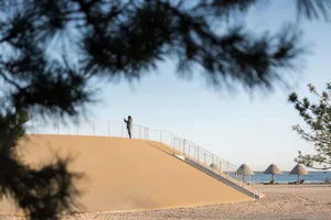 A photo of a staircase leading down to a beach area with metal steps, surrounded by a relaxing and inviting environment