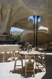 A spacious restaurant interior with multiple dining tables and chairs, creating an inviting atmosphere for a relaxed dining experience