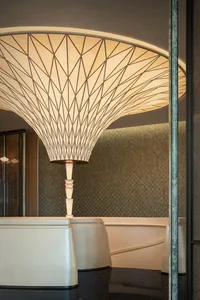 A minimalist room with a large spiral-shaped metal lamp in the center, surrounded by a clean and empty space