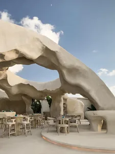 A modern dining area with a white structure, tables, and chairs, featuring a mix of modern and traditional elements