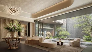 An open concept living area with a white couch near a window, two chairs, a dining table, vases, and a potted plant