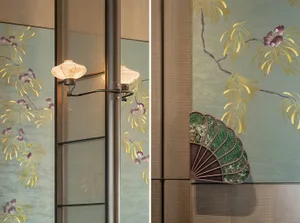 Oriental-style room with a wooden door, window, and a painting of trees on the wall, accompanied by two vases and two lamps