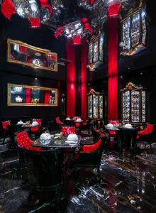Elegant restaurant interior with red walls, black tables and chairs, and artwork on the walls