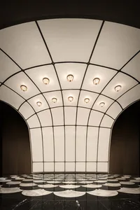 Open modern space with white walls and ceiling, illuminated by ceiling-mounted lights