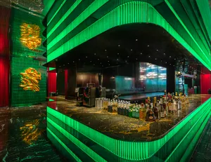 A well-stocked bar area with a large number of bottles displayed on a countertop, creating an inviting atmosphere for patrons