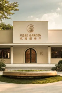 A white concrete building with a large circular window on its facade and two smaller round windows in front, possibly a garden center or similar establishment