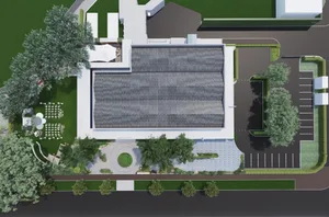 Modern building with a metal roof, white exterior, and a circular driveway surrounded by trees