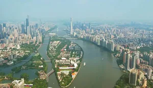 Aerial view of a bustling city with a large body of water surrounded by various buildings and boats