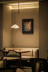 Dining area with wooden tables and chairs, a vase on one table, and an inviting atmosphere