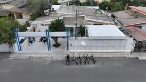 A modern and traditional building with a large white roof and a mix of concrete and wood elements, featuring a relaxed and casual outdoor space with several bicycles parked underneath