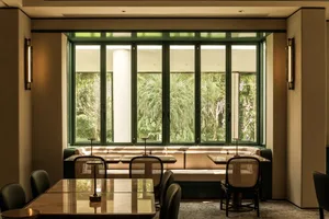 Dining area with multiple tables and chairs, well-lit for a comfortable atmosphere