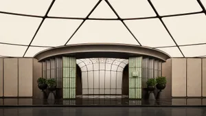 A grand hallway with a high ceiling, two potted plants, and a sense of elegance and spaciousness