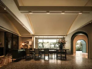 寬敞餐廳配有大餐桌、高聳天花板與明亮氛圍，桌上擺放一瓶鮮花