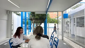 a cozy cafe with two women dining and potted plants scattered throughout