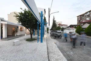 熱鬧的城市街景，設有大型白色頂篷、行人、機車與汽車