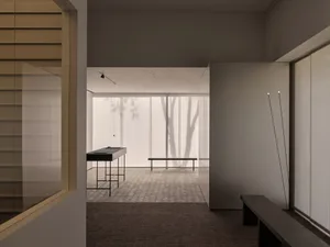 A calm and inviting lobby with two benches, a large window, and natural light