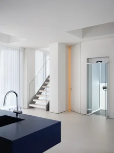 Modern bathroom with a metal staircase, white walls, and a sink in the foreground