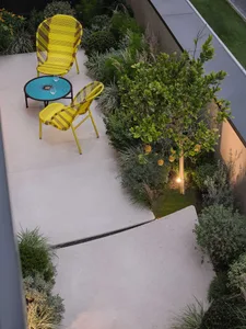 A patio area with a table and chairs, blue tablecloth, and potted plants, creating a relaxing atmosphere