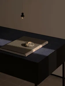 A wooden table with a book on top, in front of a wall, with a calm and organized atmosphere
