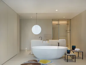 A modern bathroom with a white bathtub and two sinks, one on either side, and a mirror above the right sink