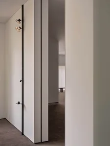 A clean and well-lit empty hallway with white walls and two doors, one on each side