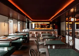 Empty restaurant interior with multiple dining tables and chairs, inviting atmosphere, and clean layout