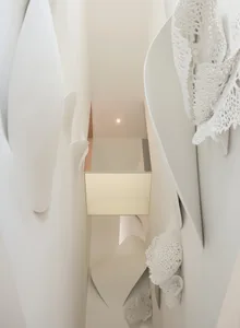 A modern hallway with curved walls and a glass box, featuring a unique design and well-lit space