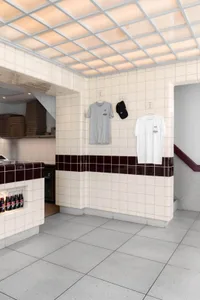 A casual restaurant interior with a tile-covered wall displaying clothing and hats, including two white shirts and three black hats