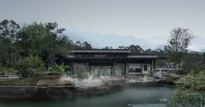 Serene Asian-style house near water with multiple rooms, chairs, and potted plants
