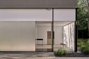 A modern kitchen with two sinks, a dining table, and chairs, surrounded by clean and well-organized space with a focus on functionality and modern design elements