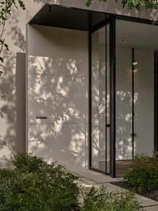 A modern indoor space with a glass door and window, featuring clean lines and minimalistic design elements, with sunlight streaming through the windows