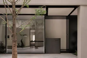 Spacious showroom with glass door, display cases, and potted plants, featuring modern and well-organized interior design