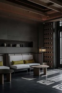 Cozy living space with two couches, a chair, and a dining table, featuring a warm and inviting atmosphere