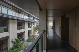 A modern building with glass walls and large windows, featuring metal balconies and a sophisticated atmosphere