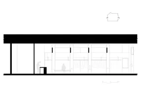 An empty building with a large window and two people standing inside, creating a calm and quiet atmosphere