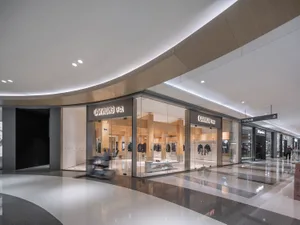 現代零售空間，擁有大型店面，特色為弧形玻璃牆，展示模特兒陳列服飾