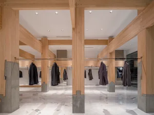 A large hallway with multiple wooden coat racks holding various jackets, creating an organized and functional space