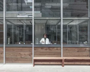 Cozy cafe interior with a wooden counter, potted plants, and various items on display