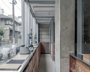Industrial kitchen with two sinks, a microwave, oven, and various appliances and equipment, with a functional and well-equipped atmosphere