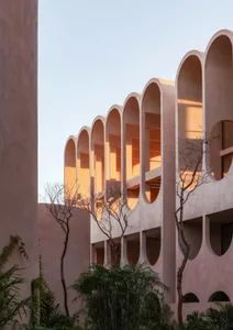 A modern building with a unique design featuring round shapes and arches, with multiple windows on its facade